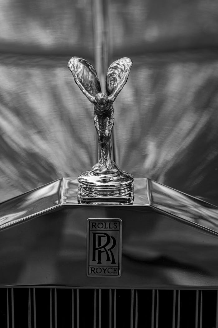 Dramatic black and white photo of the Rolls-Royce hood ornament showcasing luxury and elegance.